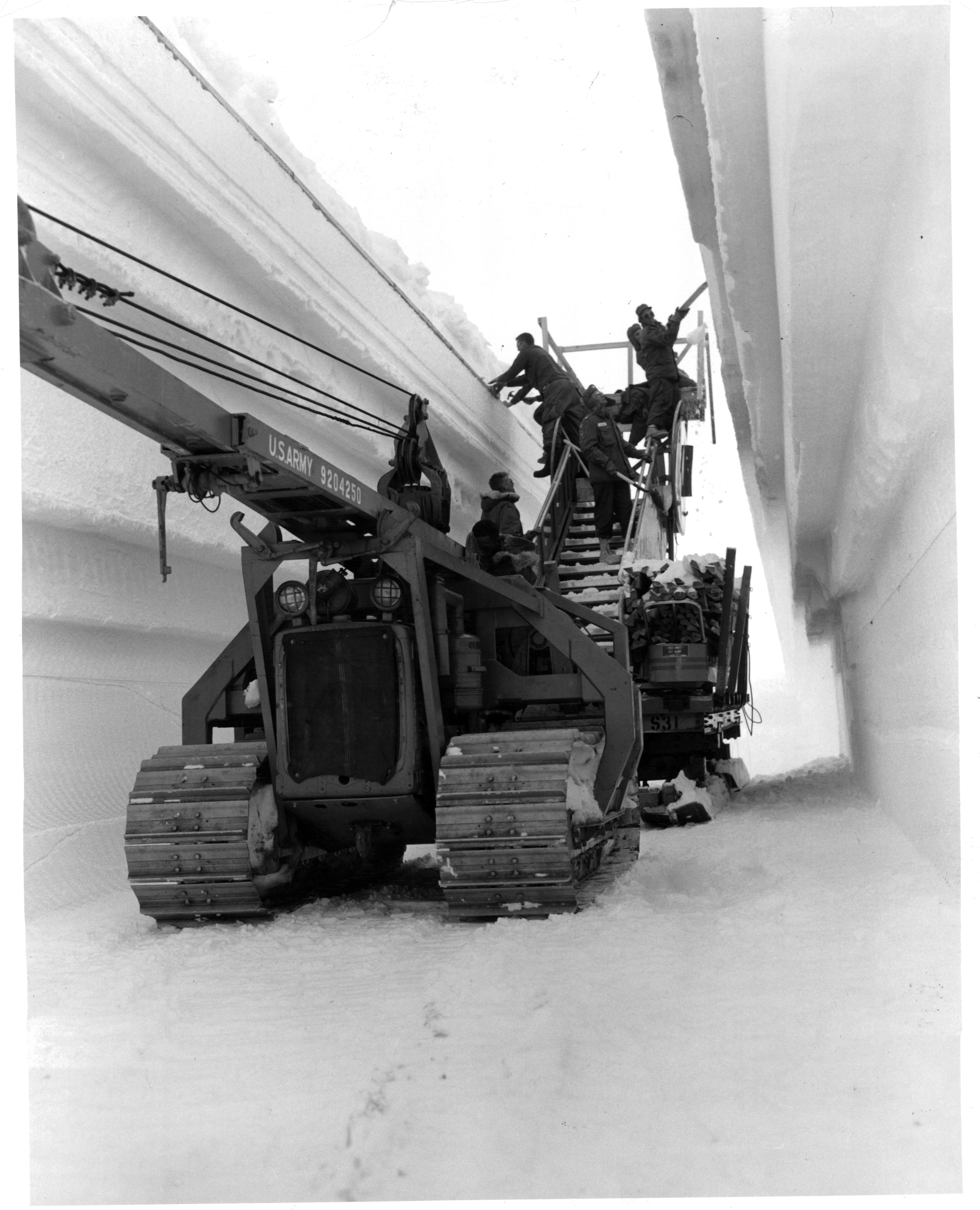 Men place arch supports in the tunnel to main trench of the permanent camp at Century Camp, Greenland.