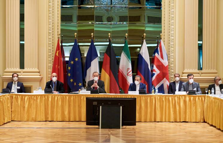 world leaders sit in front of flags