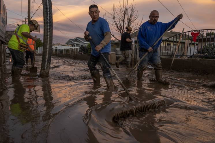 Residents work to push back wet mud that trapped cars and invaded some houses on January 11, 2023 in the small unincorporated town of Piru, east of Fillmore, California. A series of powerful storms continues to pound California in striking contrast to the past three years of severe to extreme drought experienced by most of the state.; Getty Images