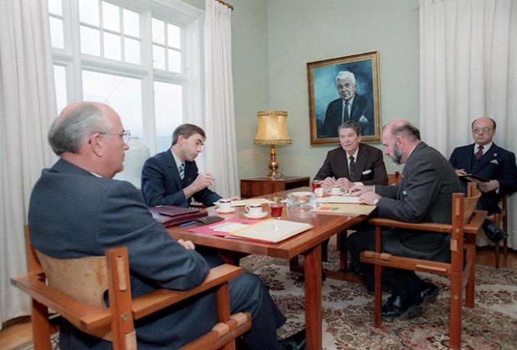 President Reagan and General Secretary Gorbachev in discussion, seated at a table in a meeting room in Reykjavik, Iceland.