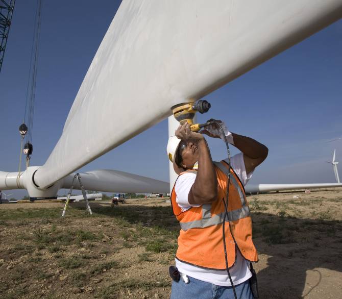 Construction workers with the help of a crane sand the surface of a propeller at a tower base on the Lone Star Wind Farm on June 7, 2007, 17 miles north of Abilene, Texas. Revenue for ranchers can range from $5,000 to $50,000 per month per tower depending on the variable wind strengths. Getty Images
