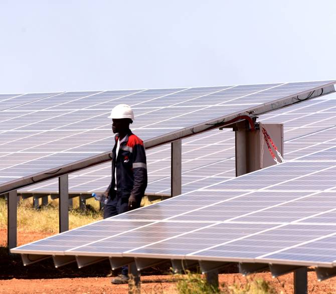 A technician walks through solar panels on October 22, 2016 during the opening ceremony of a new photovoltaic energy production site in Bokhol. Senegal; Getty
