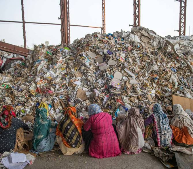 Workers at a paper mill in Muzaffarnagar sort through imported raw materials to remove plastic waste.