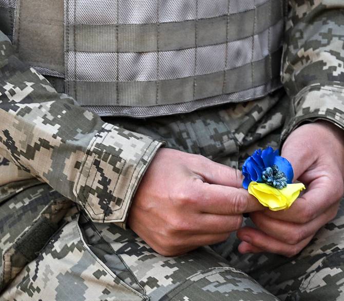 Ukrainian soldier holding a flower