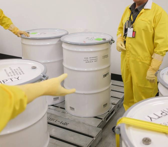 At the New Employee Training (NET) facility of the Los Alamos National Laboratory (LANL), empty waste drums are set up for a “Container Handling for Waste Operators” training session.