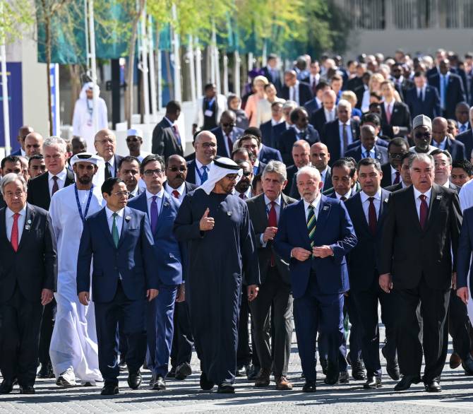 COP28 President Sultan Ahmed al-Jaber, center, walks with world leaders and representatives of countries to the climate summit’s opening ceremony. The loss and damage fund was one of the first items approved