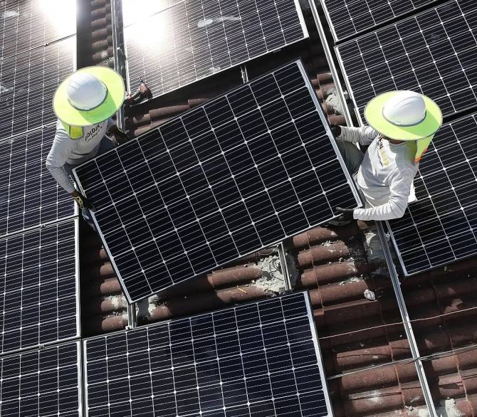  Roger Garbey and Andres Hernandez (L-R), from the Goldin Solar company, install a solar panel system on the roof of a home a day after the Trump administration announced it will impose duties of as much as 30 percent on solar equipment made abroad on January 23, 2018 in Palmetto Bay, Florida. 