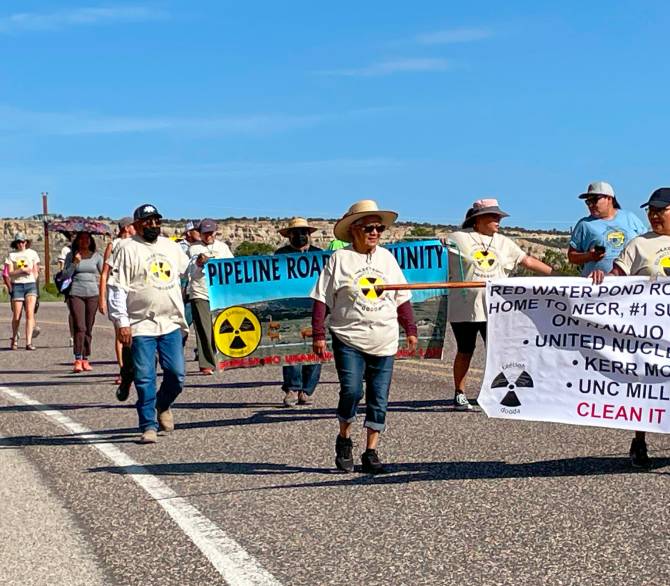 Residents and supporters walk southbound on New Mexico Highway 566 to the defunct uranium ore processing mill during the event on July 13 to remember the Church Rock uranium spill. Credit: Noel Lyn Smith/Inside Climate News