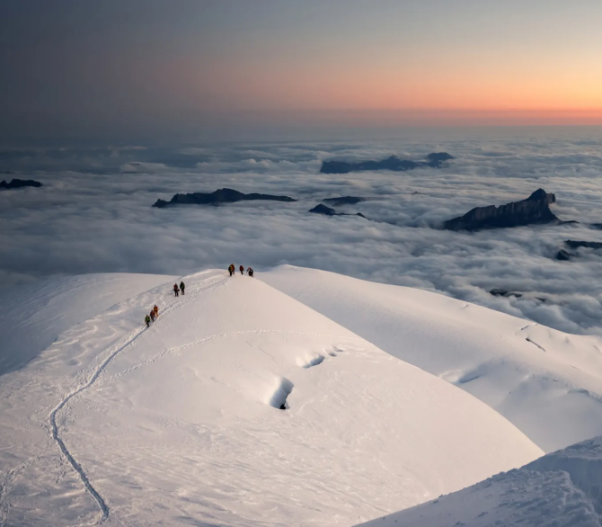 Alpinists at 4,500m on the Arête des Bosses, part of the popular Goûter route to the top of Mont Blanc, at dawn.