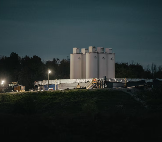 Bright lights illuminate sand silos at an oil drilling site operated by Coterra in the small town of Dimock, Pennsylvania, in October. The resumption of drilling in the region comes as both Donald Trump and Kamala Harris seek to position themselves to Pennsylvania voters as advocates of fracking.