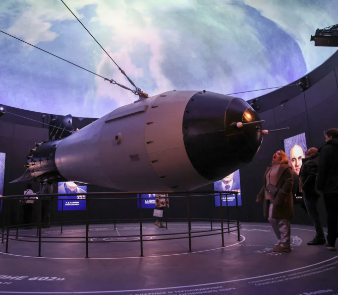 Visitors look at a model of a Soviet AN-602 thermonuclear aerial bomb also known as the Tsar Bomb, the most powerful nuclear weapon ever created and tested, as they visit the Atom pavilion, at the All-Russia Exhibition Centre in Moscow on November 4, 2023.