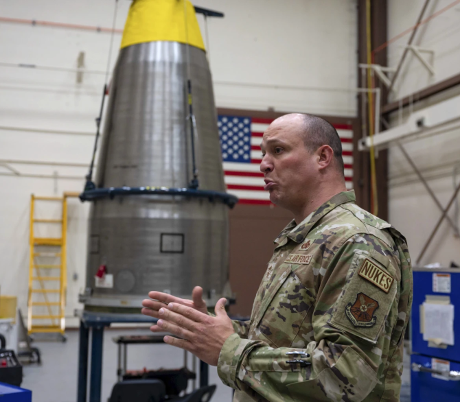 In this image provided by the U.S. Air Force, Chief Master Sgt. Andrew Zahm speaks in front of the top of Minuteman III intercontinental ballistic missile shroud at F.E. Warren Air Force Base, Wyo., Aug. 16, 2023. Zahm has worked on the military's nuclear missile mission for 21 years. The increased workload of maintaining old missiles with fewer people has made it harder to convince younger troops to stay, especially because with their critical skillset they could make more money in the private sector. 