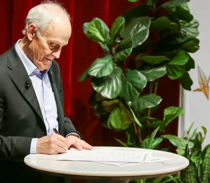 David Gross, who won the 2004 Nobel Prize in Physics, signs the Declaration for the Prevention of Nuclear War in Chicago, July 16, 2025. 