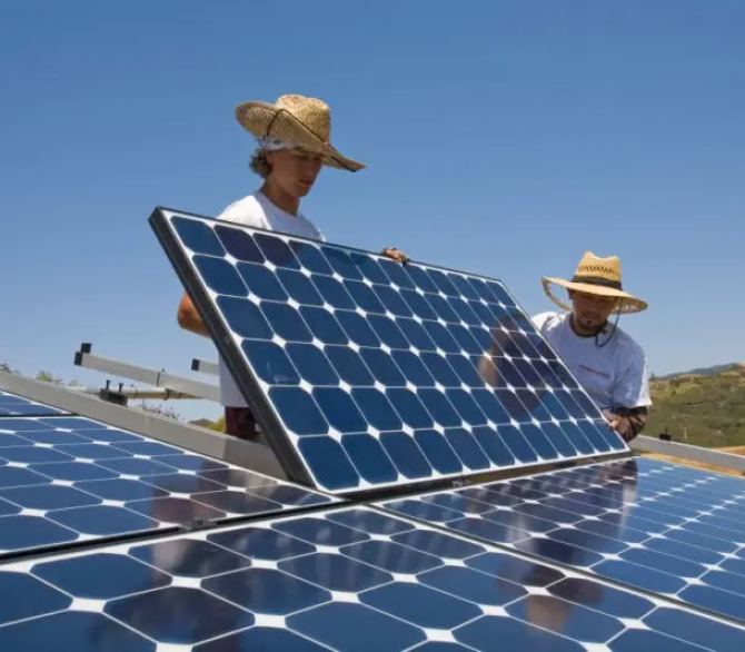 Green workers install a residential grid-tied solar array on a hillside in Malibu, California, USA. 