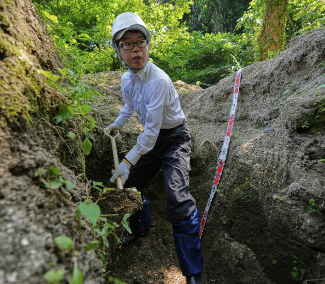 Rebun Kayo, a Hiroshima University researcher, searches for remains of victims of the 1945 Hiroshima bombing in Ninoshima in Hiroshima, western Japan, Tuesday, July 8, 2025. 