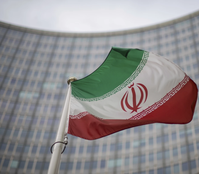 A national flag of Iran waves in front of the building of the International Atomic Energy Agency, IAEA, in Vienna, Austria, Friday, Dec. 17, 2021. 