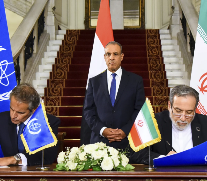 In this handout photo release by Egyptian Foreign Ministry Press Service, Iranian Foreign Minister Abbas Araghchi, right, and Director General of the International Atomic Energy Agency (IAEA) Rafael Grossi, left, sign an agreement to open the way for resuming cooperating, at Tahrir Palace in Cairo, Egypt, Tuesday, Sept. 9, 2025.