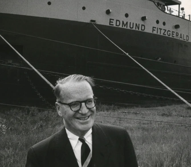 Edmund Fitzgerald with the ship Edmund Fitzgerald in the background.