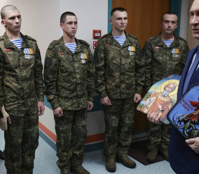 President Vladimir Putin holds Russian Orthodox icons as he meets with soldiers wounded in action in Ukraine, at the Mandryk Central Military Clinical Hospital, in Moscow, Russia, Wednesday, Oct. 29, 2025. 