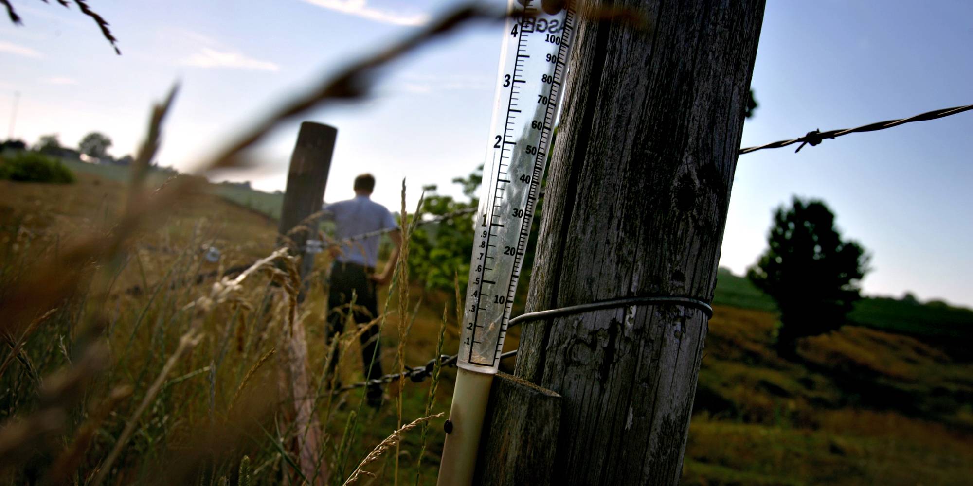 An empty rain gauge sits on a fence post on an Illinois farm.