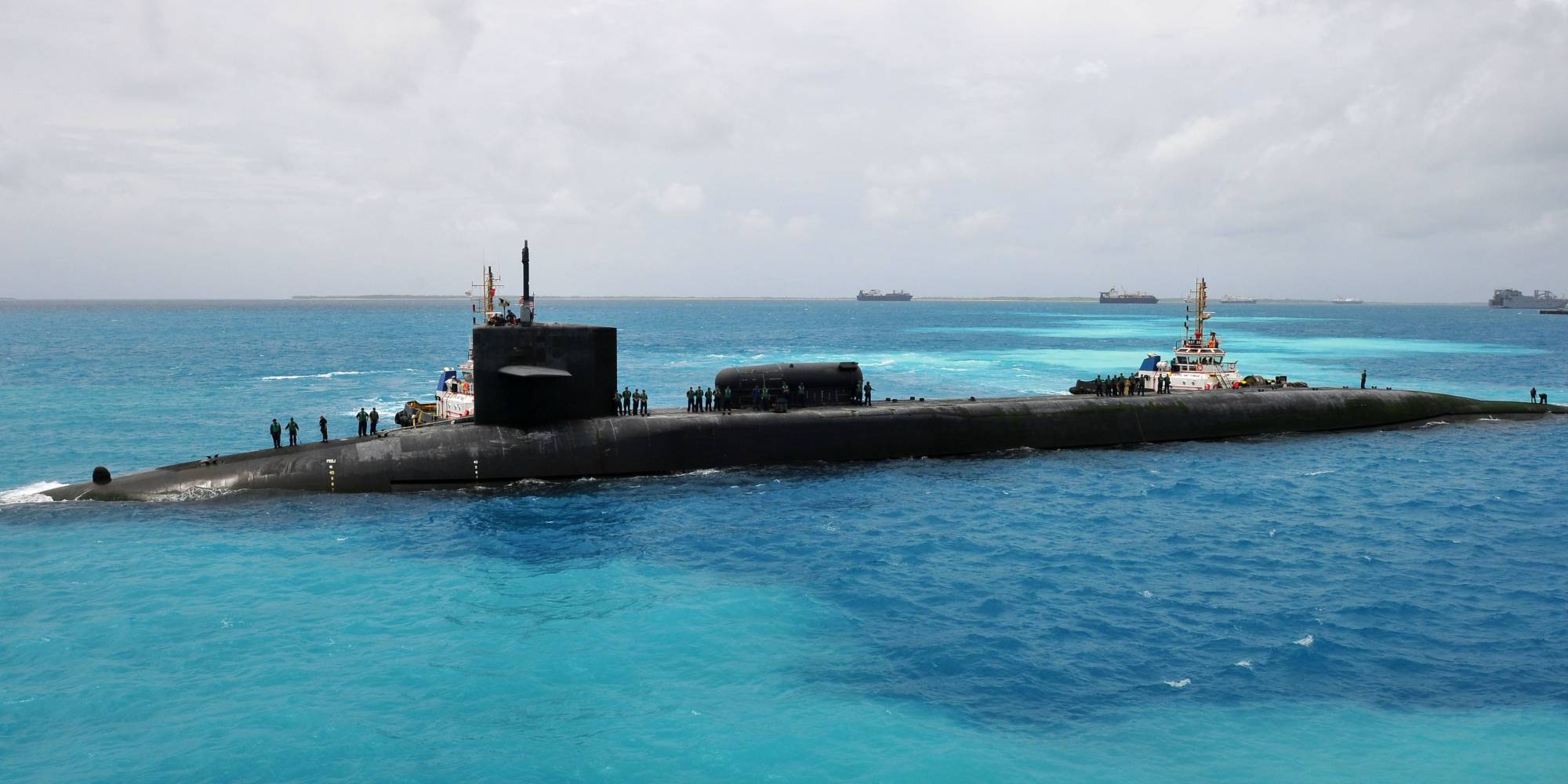 submarine in the the water with soldiers standing on top